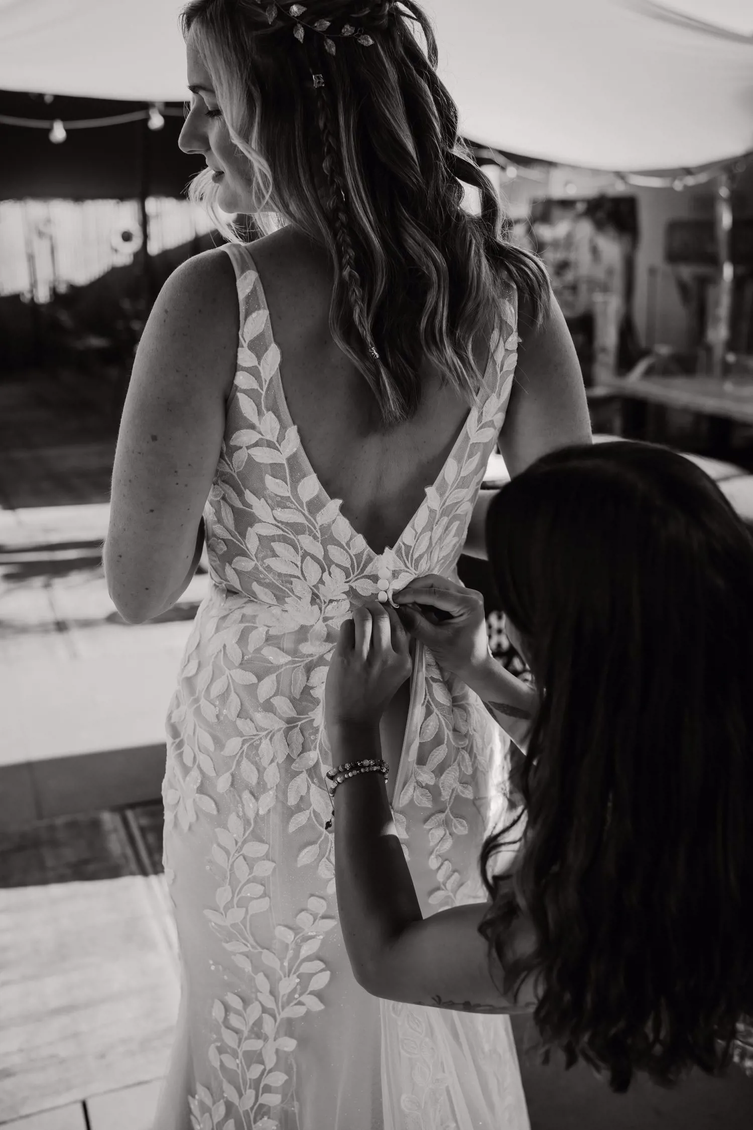 Real bride Lisa van Dooren tijdens het aankleden, in een romantische fit & flare jurk met open rug en bladkant.