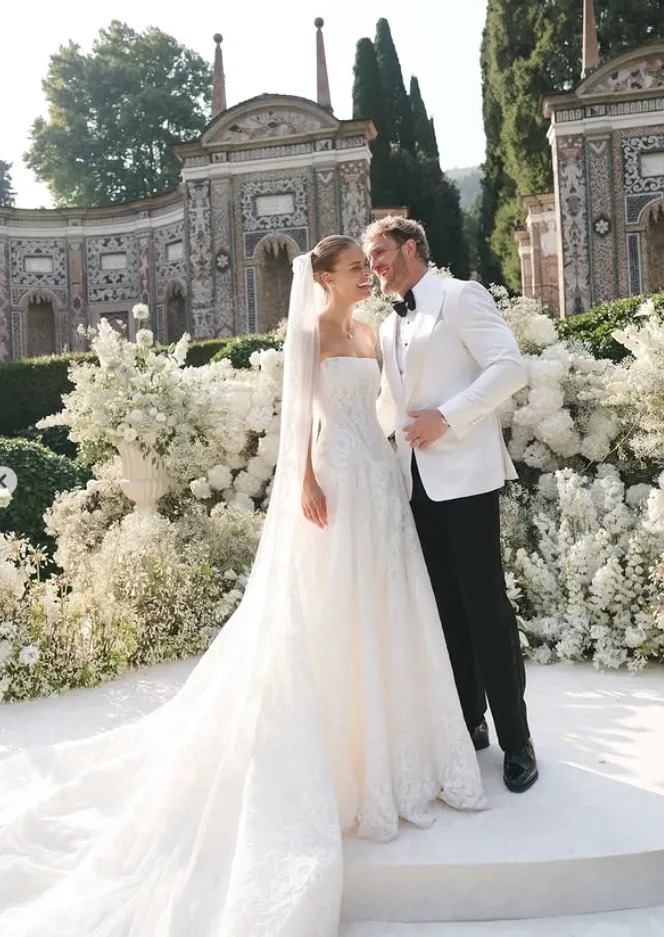 Galia Lahav bride Nina Agdal in strapless lace A-line wedding dress Splendid with long veil standing with groom at luxury outdoor ceremony.