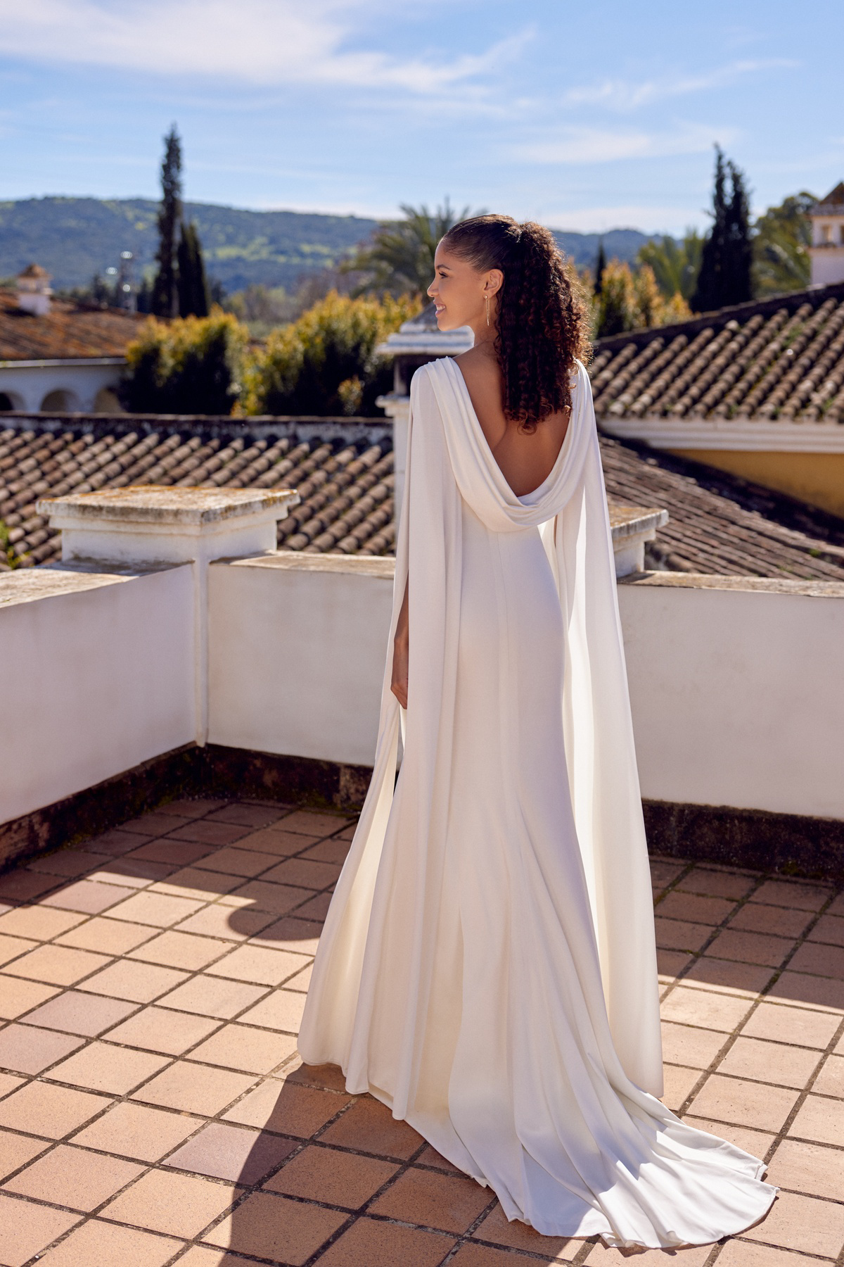 Bruidsjurk met cape 66434 van Lillian West. Achteraanzicht van de aangesloten trouwjurk met een elegante, lage rug.