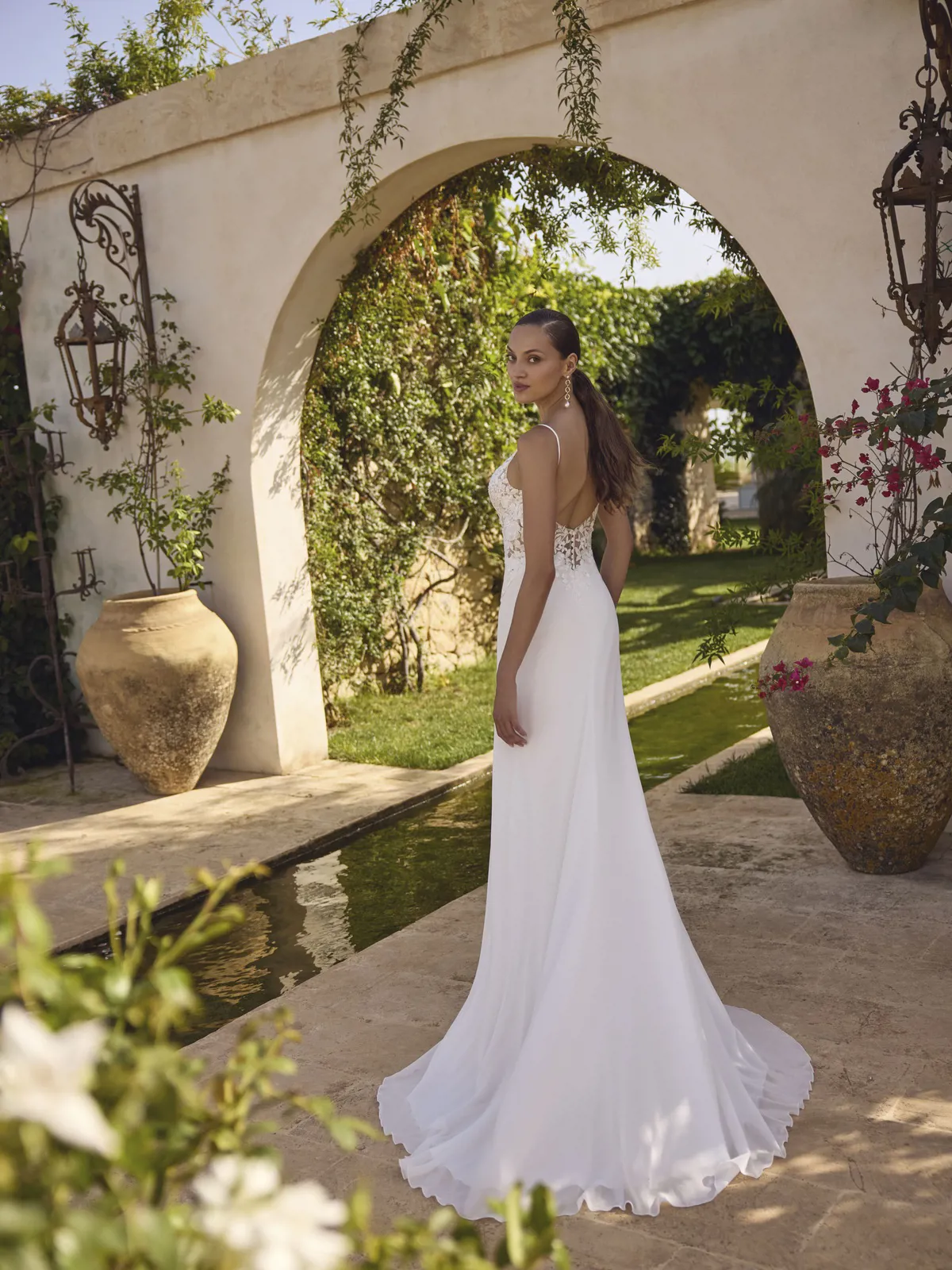 Trouwjurk met lage rug Glamour van Modeca. Achteraanzicht met een kanten lijfje en flowy chiffon rok.