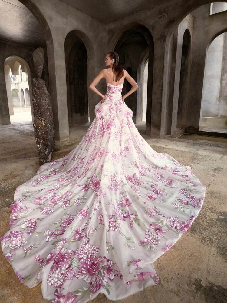 Gekleurde trouwjurk Fiori van Galia Lahav. Achteraanzicht van de prinsessenjurk met lange sleep en roze bloemenprint.