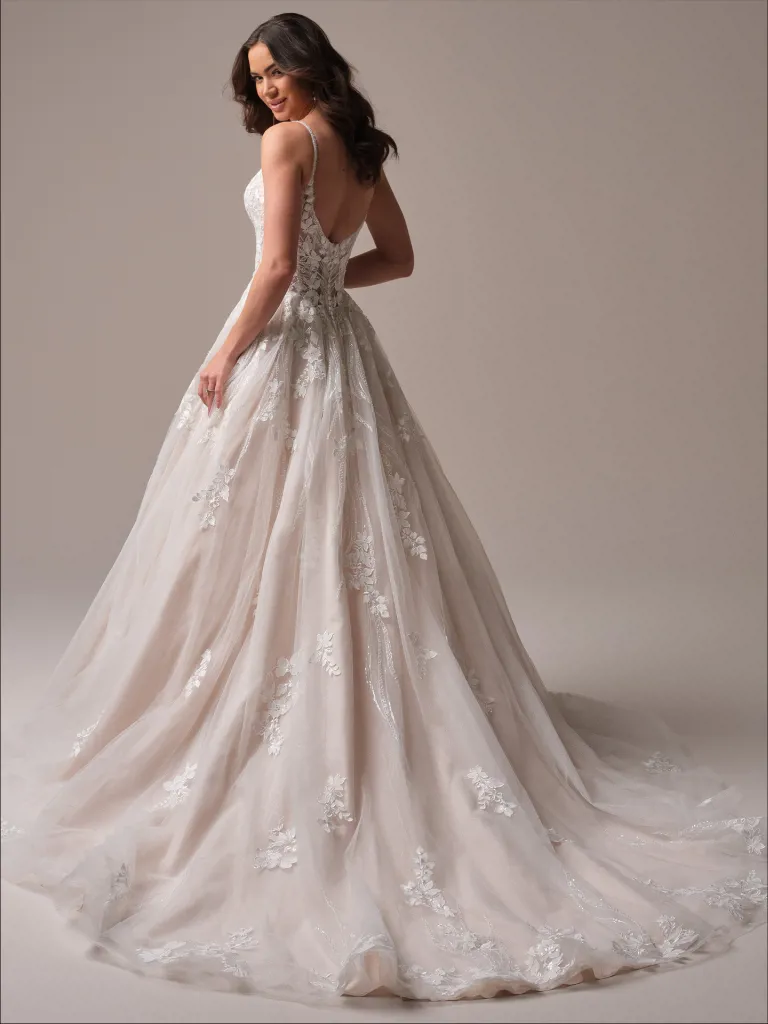Trouwjurk met lage rug Liberty van Maggie Sottero, achteraanzicht van de prinsessenlijn rok met kant en een lange sleep.