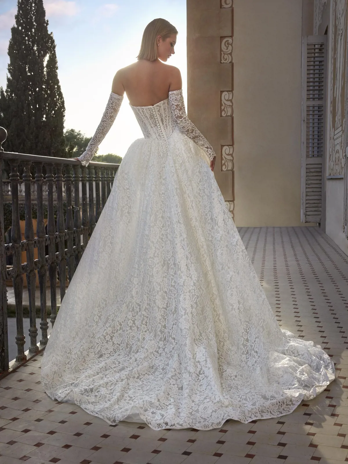 Prinsessen trouwjurk Beatris van Pronovias Privee. Achteraanzicht van het kanten korsetlijfje met losse mouwen en wijde rok.