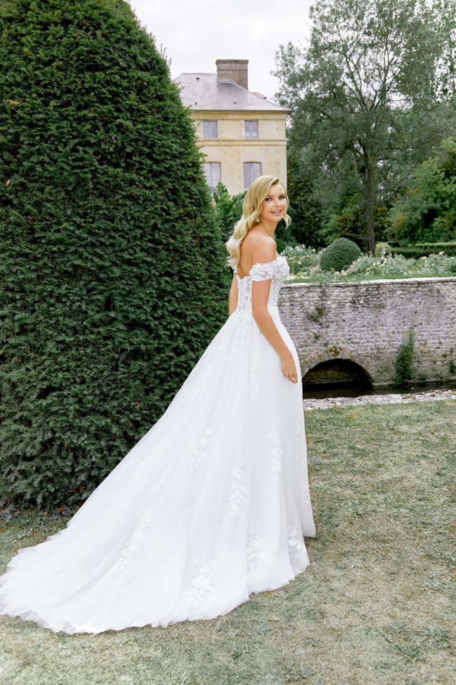 Romantische A-lijn trouwjurk 44520 van Sincerity Bridal. Achteraanzicht met off-shoulder kanten mouwtjes en tule rok.