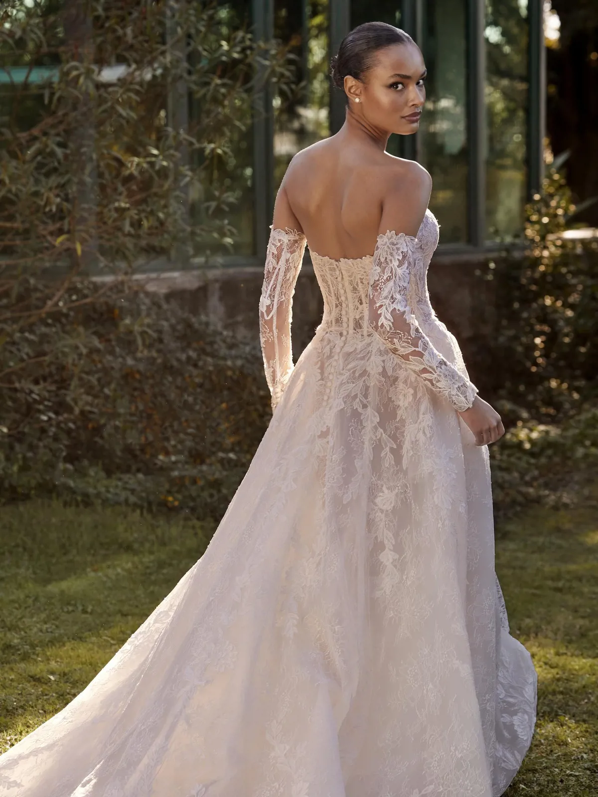 Trouwjurk met open rug Dabri van Pronovias, achteraanzicht. Volledig kanten A-lijn jurk met off-shoulder mouwen.