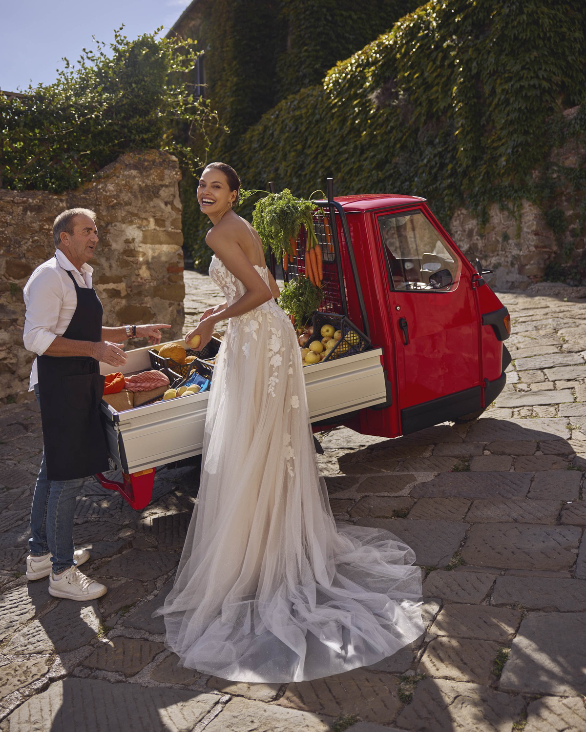 Trouwjurk A-lijn Geralyn van Modeca. Zijaanzicht van de strapless jurk met bloemenkant en een subtiele glitter tule rok.
