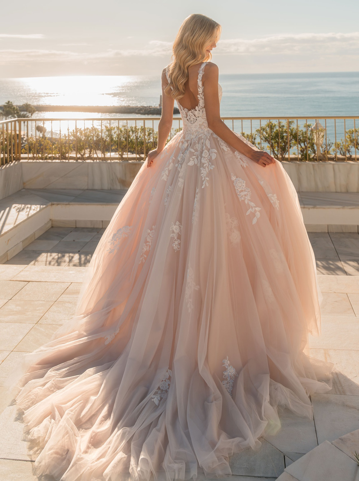 Prinsessen trouwjurk 31013 Diane Legrand met lage rug. Achteraanzicht van de blush tule rok met romantische kanten details.