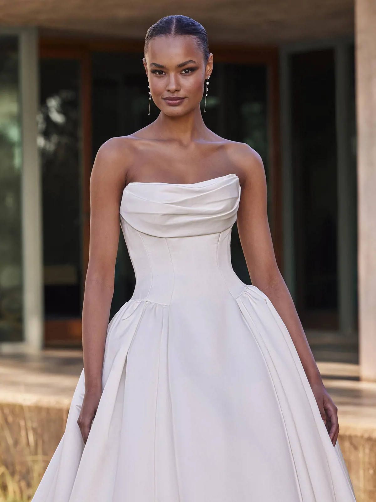 Strapless trouwjurk Pronovias Cillian met gedrapeerd lijfje en basque waist. Close-up van de satijnen bruidsjurk.
