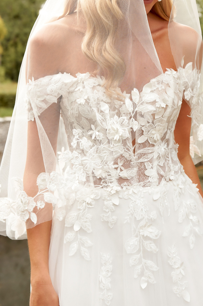 Off-shoulder trouwjurk 44520 van Sincerity Bridal. Close-up van het see-through lijfje met romantisch 3D kant.