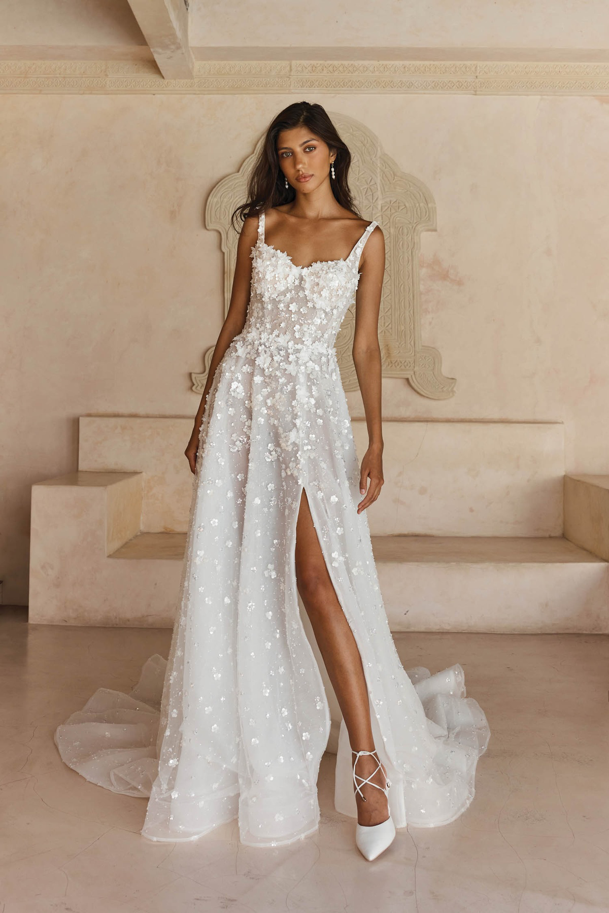 A-lijn trouwjurk Leisel van Madi Lane met 3D bloemen en een hoge split. Vooraanzicht van deze flowy bruidsjurk.