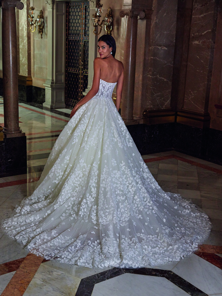 Prinsessenjurk DP546 van Demetrios Platinum. Achteraanzicht van de strapless trouwjurk met bladapplicaties en lange sleep.