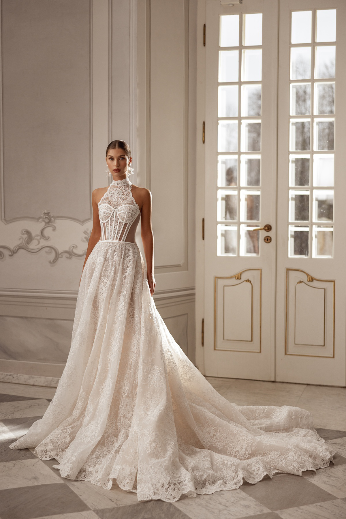 Trouwjurk met korset Jane van Tina Valerdi. Vooraanzicht van de kanten A-lijn met hoge hals, exclusief bij Bruidshuis Diana.