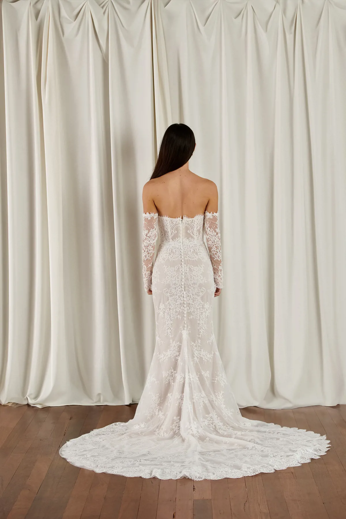 Kanten zeemeermin trouwjurk 23112 Cizzy Bridal. Achteraanzicht met off-shoulder lange mouwen en een verfijnde kanten sleep.