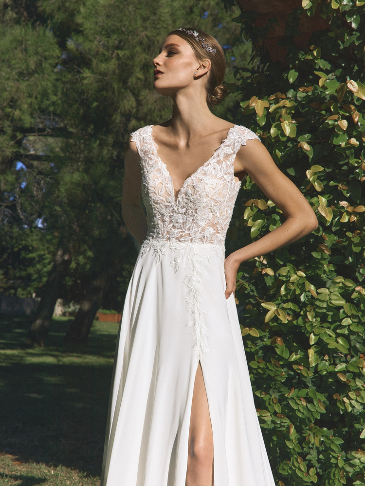 A-lijn trouwjurk Alguem van White one zijaanzicht met kanten see-through lijfje en een hoge split in de flowy rok.