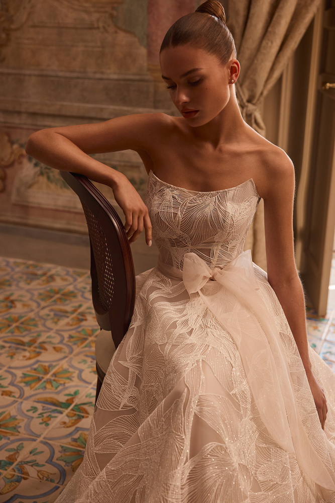 Trouwjurk Octavianna van Aria met uniek glitterpatroon. Close-up van de strapless A-lijn jurk met moderne strik in de taille.