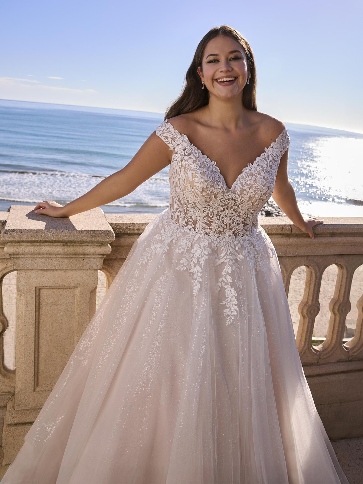 A-lijn bruidsjurk Lelies van Ladybird in vooraanzicht met off-shoulder kanten kapmouwtjes en een subtiele glitter tule rok.