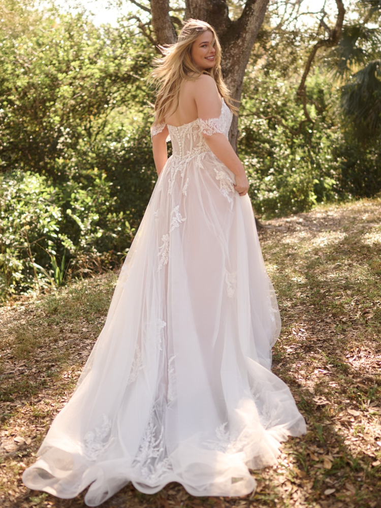 Plus-size A-lijn trouwjurk Victoria Curvy van Maggie Sottero. Achteraanzicht met off-shoulder kanten top en romantische tule rok.