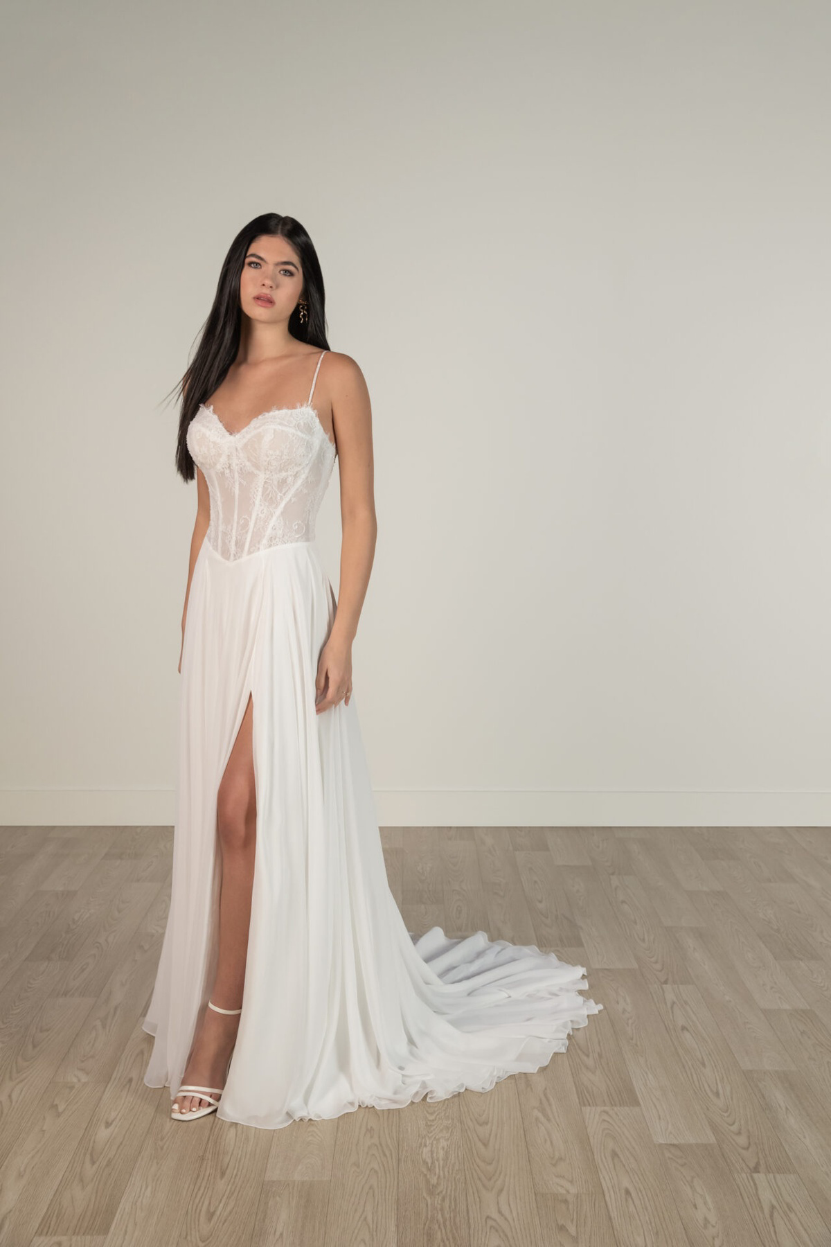 Trouwjurk met split 8140 van Stella York. Vooraanzicht van de A-lijn jurk met een doorschijnend kanten korsetlijfje.