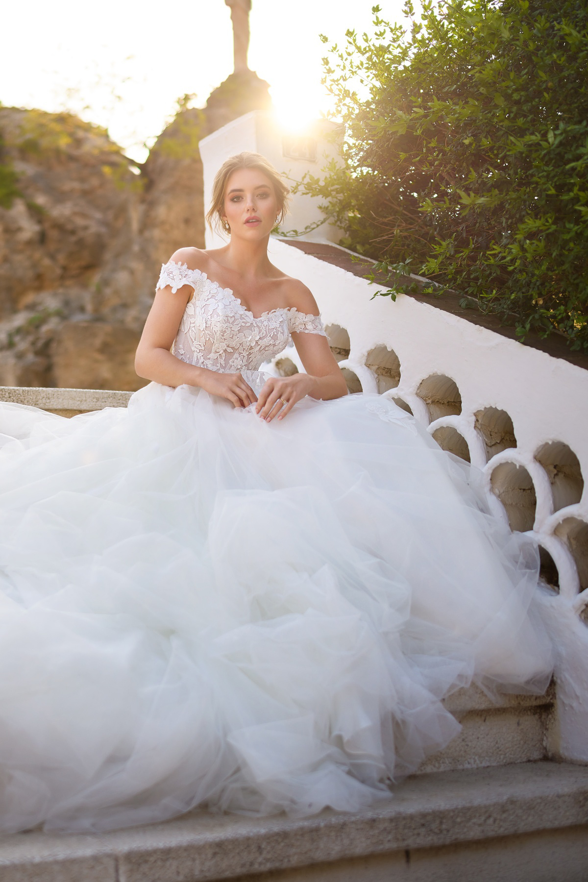 Off-shoulder trouwjurk 26206 van Tres chic. Vooraanzicht van deze prinsessenjurk met een kanten lijfje en wijde tule rok.