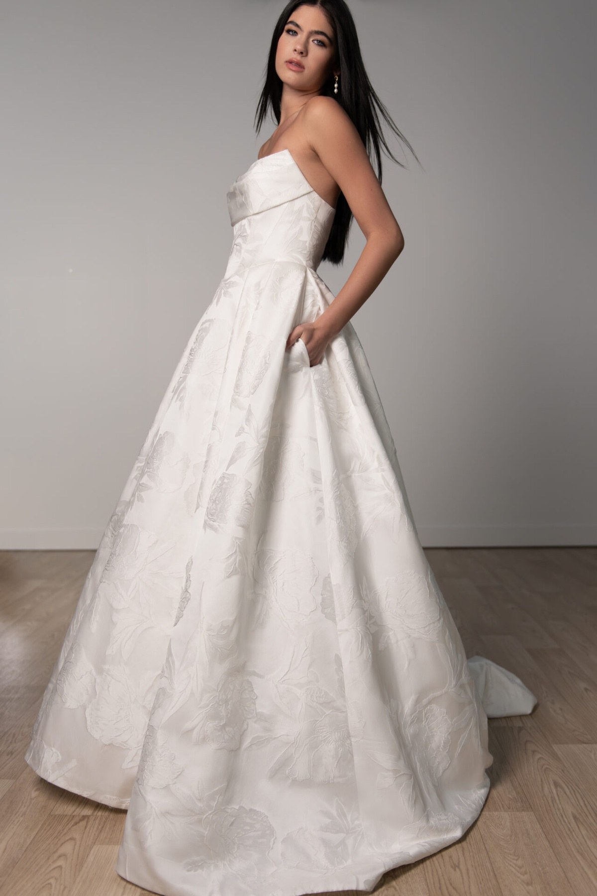 A-lijn trouwjurk 8084 van Stella York met strapless lijfje en zakken. Zijaanzicht van de jurk met bloemenpatroon.