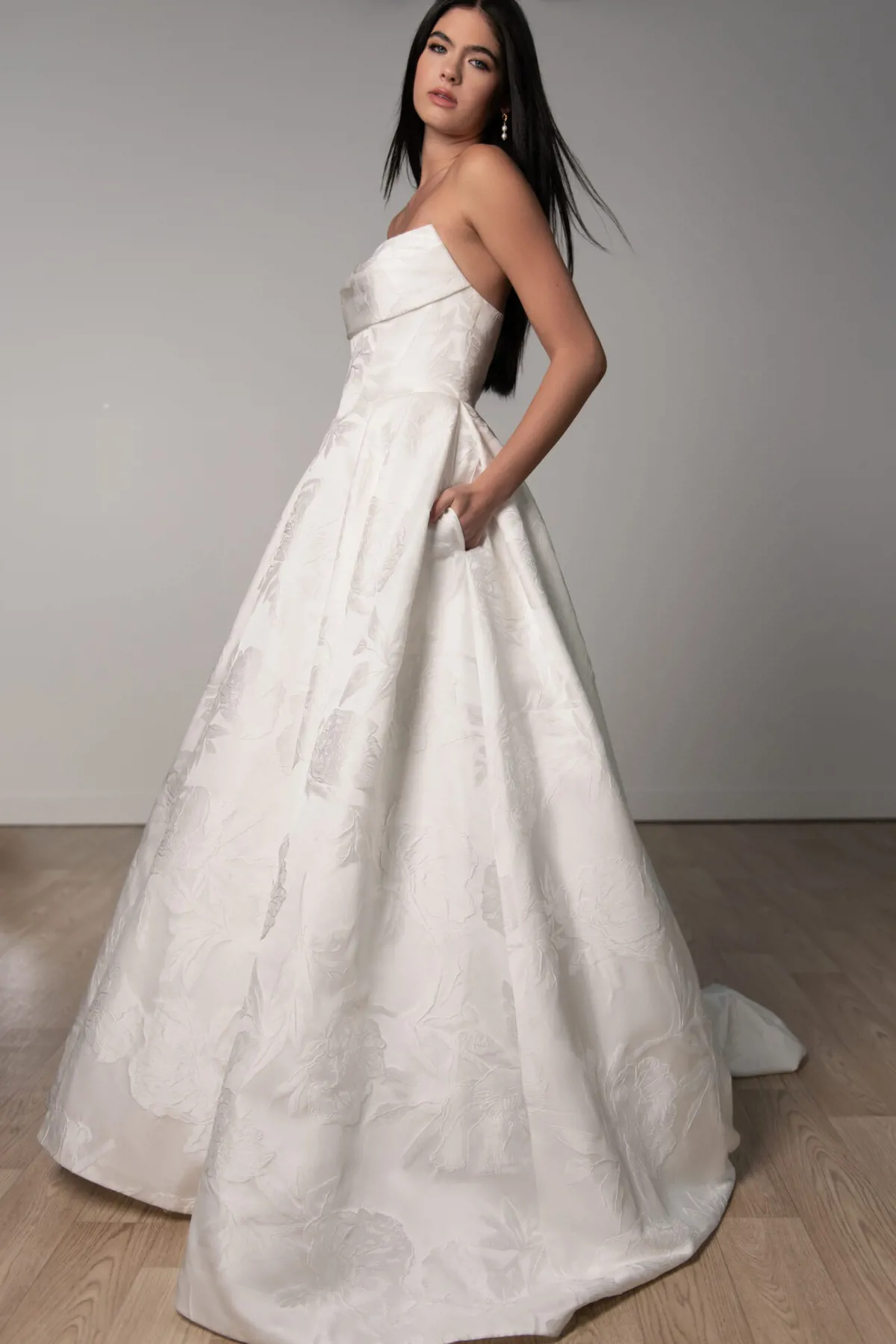 A-lijn trouwjurk 8084 van Stella York met strapless lijfje en zakken. Zijaanzicht van de jurk met bloemenpatroon.
