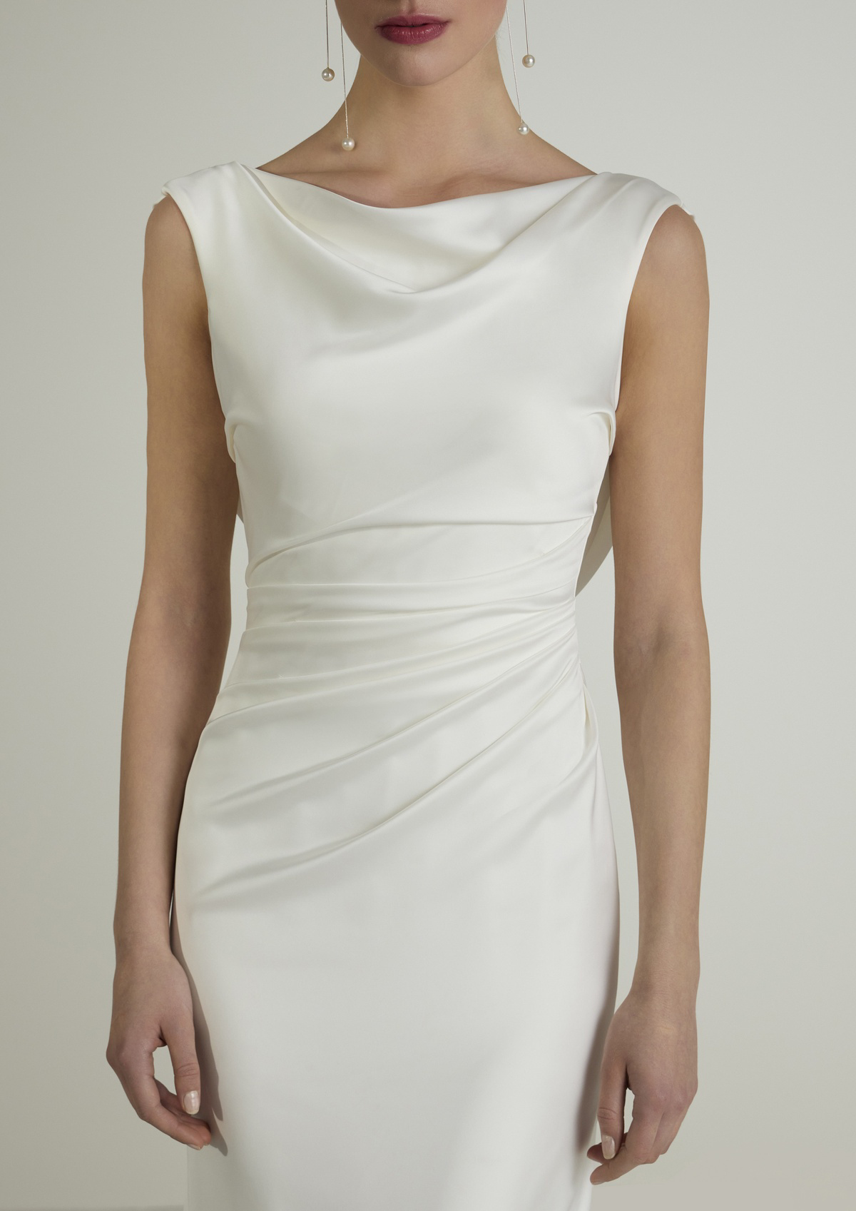 Trouwjurk Mediva van San Patrick van satijn. Close-up van het gedrapeerde lijfje en de elegante watervalhals.