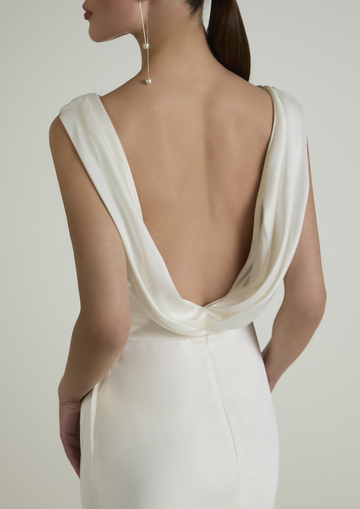 Trouwjurk met open rug Mediva van San Patrick. Achteraanzicht van de satijnen bruidsjurk met elegante gedrapeerde rug.