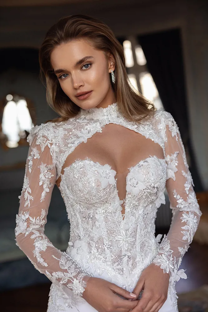 Trouwjurk Menta van Pronovias met lange mouwen. Close-up van het lijfje met 3D kant, glitter en hoge hals.