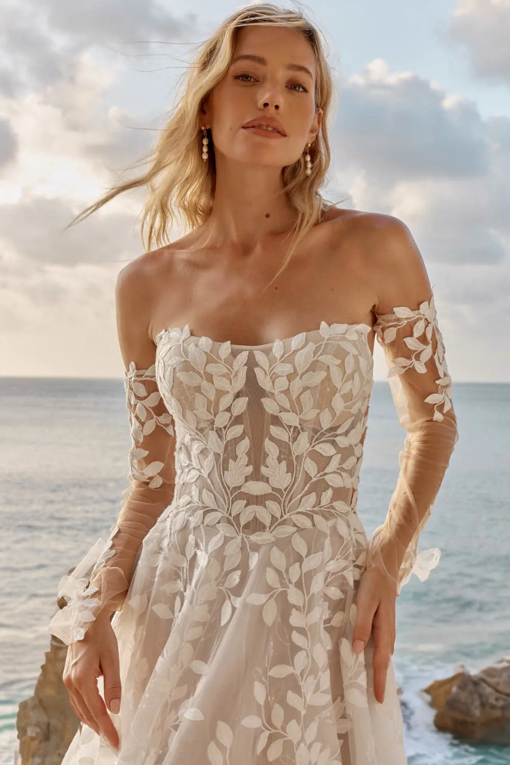 Off-shoulder trouwjurk Laiya van Madi Lane met blaadjeskant en see-through korsetlijfje. Close-up van de voorzijde.