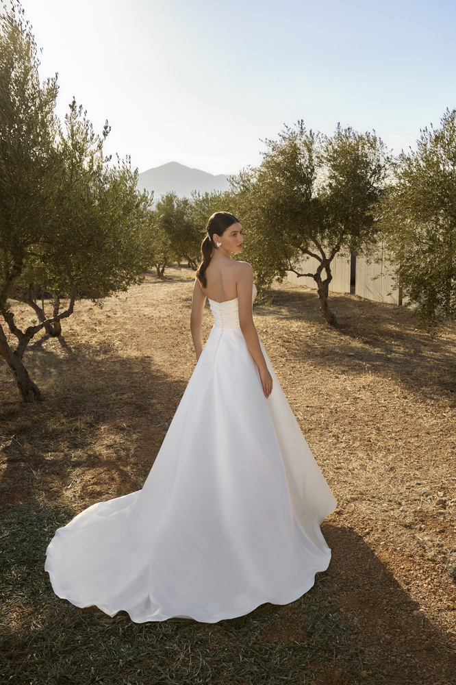 Klassieke A-lijn bruidsjurk L1152 van Orea sposa. Achteraanzicht van de strapless satijnen trouwjurk met picpac knoopjes.