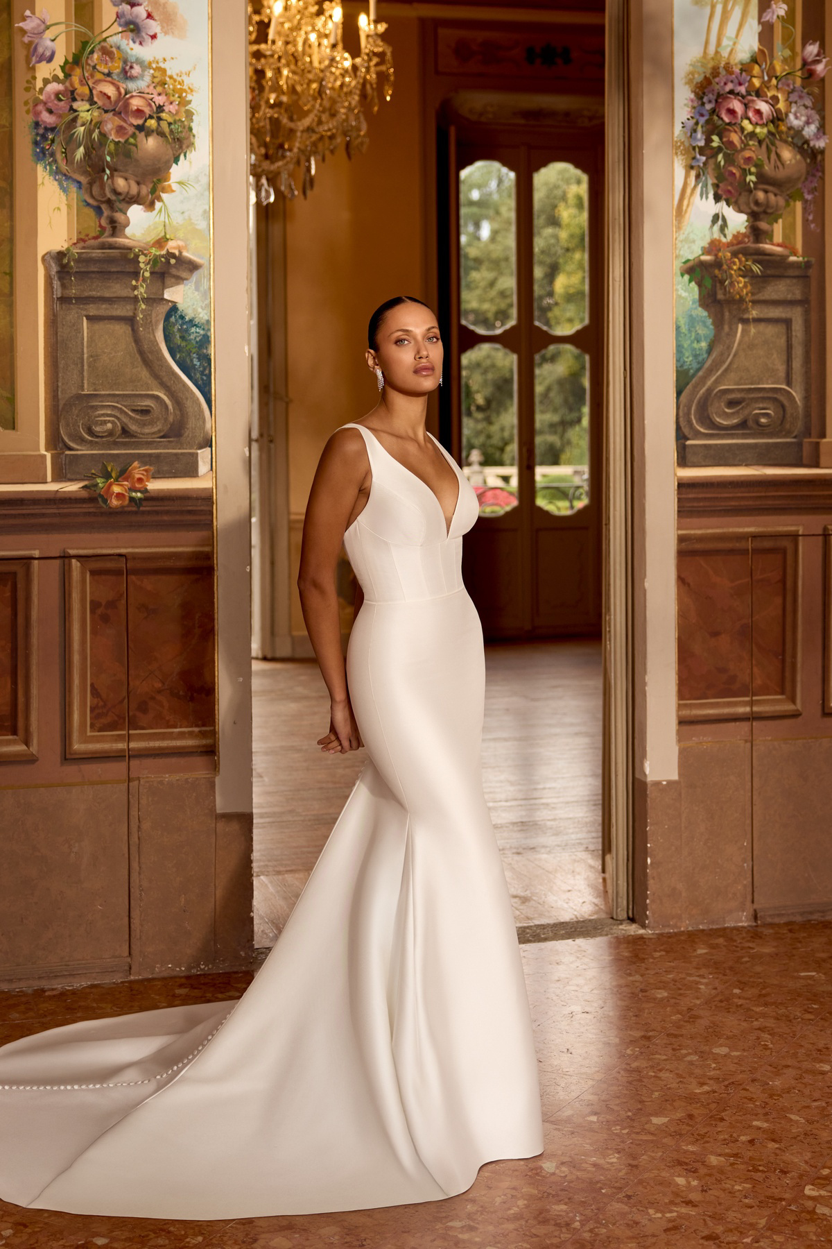 Satijnen zeemeermin trouwjurk Kassie van Justin Alexander. Vooraanzicht van de jurk met diepe V-hals en korsetlijfje.