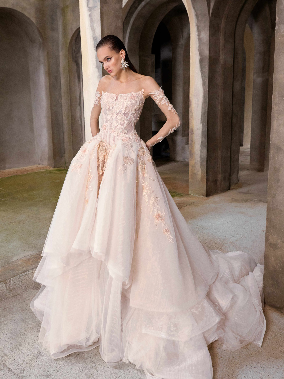 Off-shoulder trouwjurk Venezia van Galia Lahav in blush met 3D kant en gelaagde rok, verkrijgbaar bij Bruidshuis Diana.