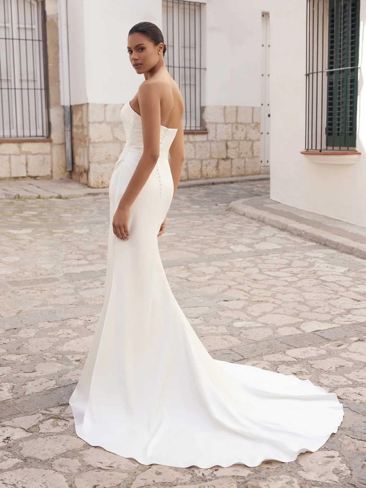 Strapless zeemeermin trouwjurk Lighty van White one. Achteraanzicht met picpac knoopjes en een gedrapeerd lijfje.