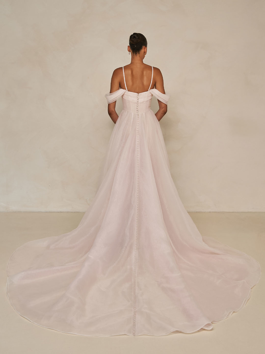 Blush A-lijn trouwjurk Wisteria van Ines di Santo met lage rug en off-shoulder bandjes. Achteraanzicht met lange sleep.