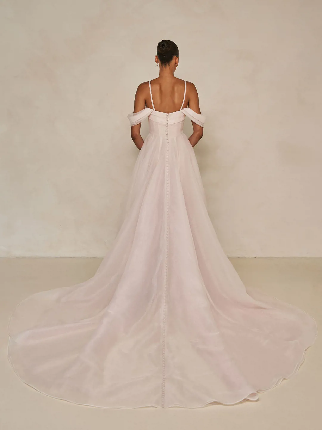 Blush A-lijn trouwjurk Wisteria van Ines di Santo met lage rug en off-shoulder bandjes. Achteraanzicht met lange sleep.