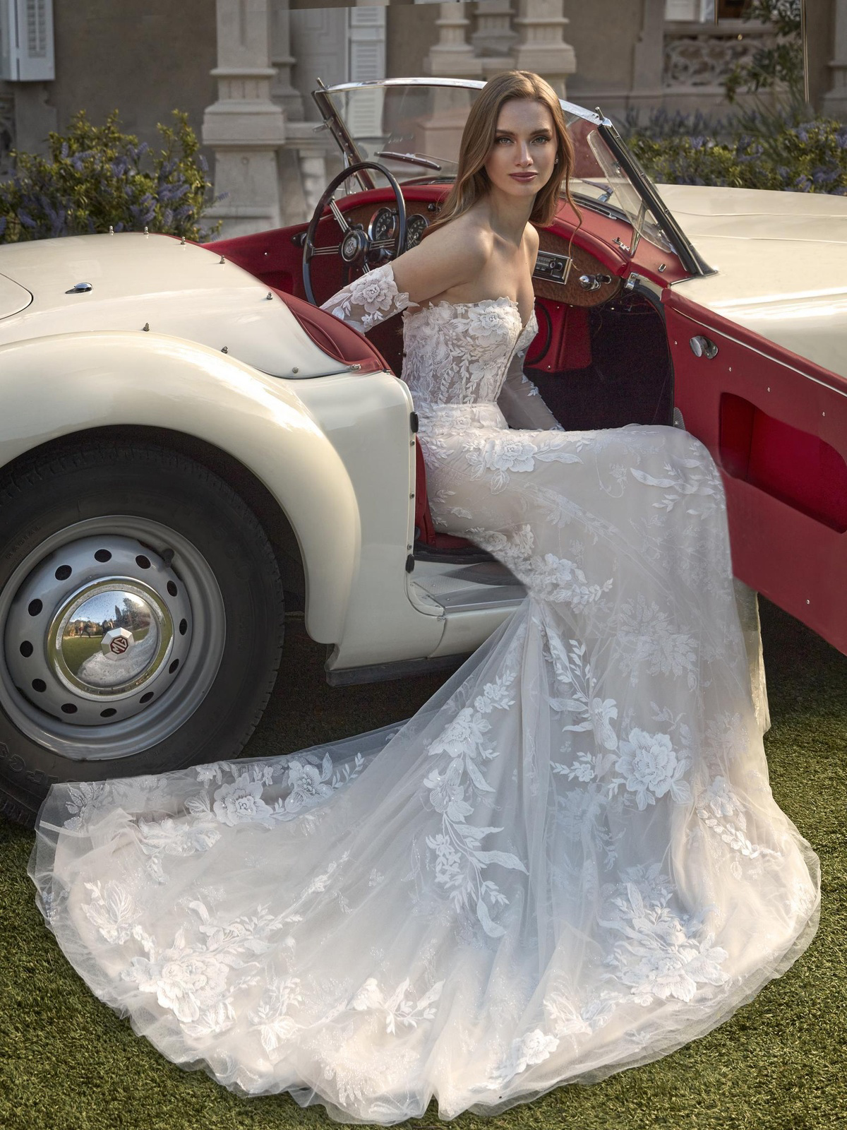 Zeemeermin trouwjurk Aude van San Patrick. Zijaanzicht van de strapless bruidsjurk met bloemenkant en afneembare mouwen.