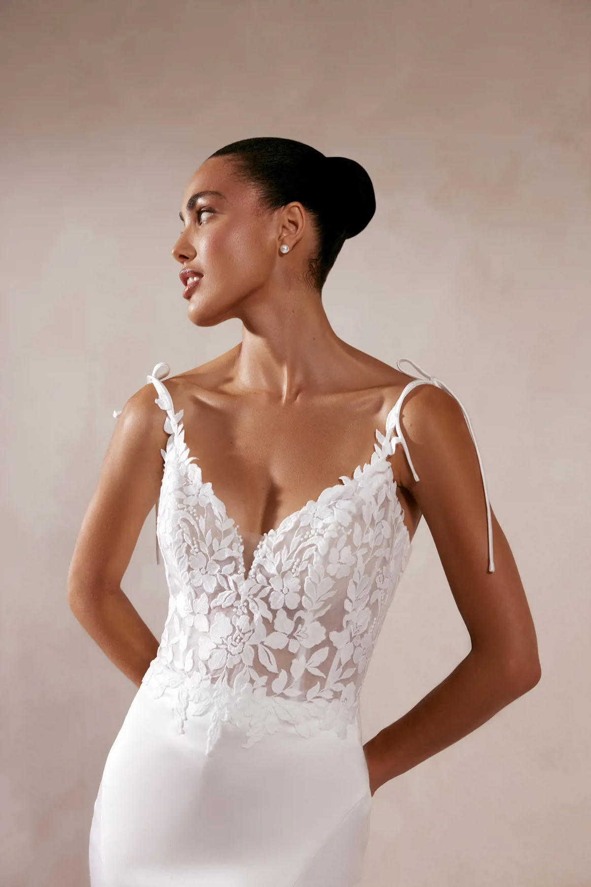 Trouwjurk met kant Akemi van Adore. Close-up van het see-through lijfje met V-hals en romantische strikbandjes.