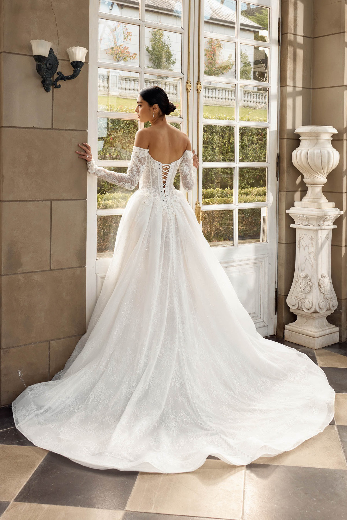 Off-shoulder trouwjurk Italia van Jeune by Madi Lane met open rug en korset. Achteraanzicht van deze prinsessenjurk.