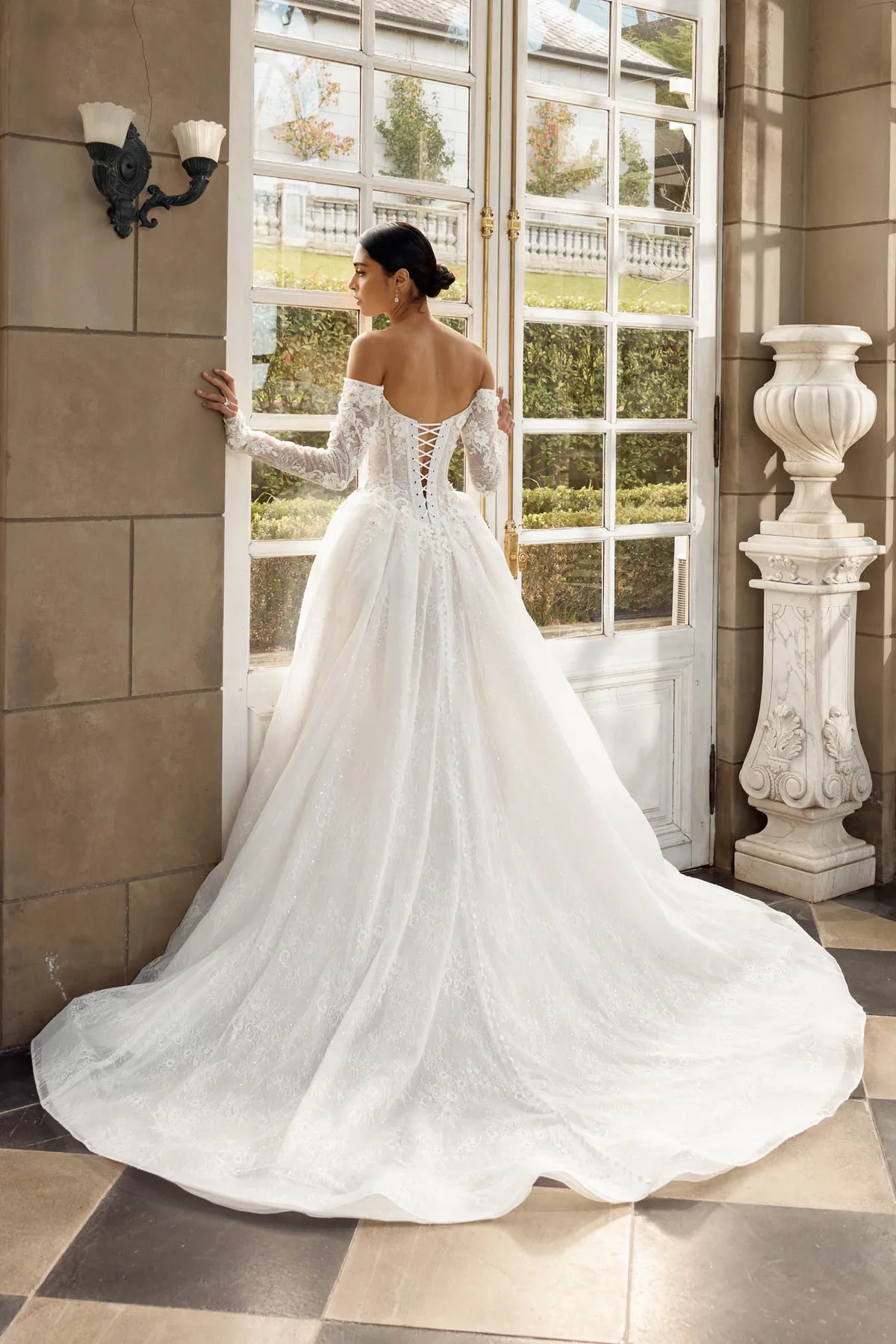 Off-shoulder trouwjurk Italia van Jeune by Madi Lane met open rug en korset. Achteraanzicht van deze prinsessenjurk.