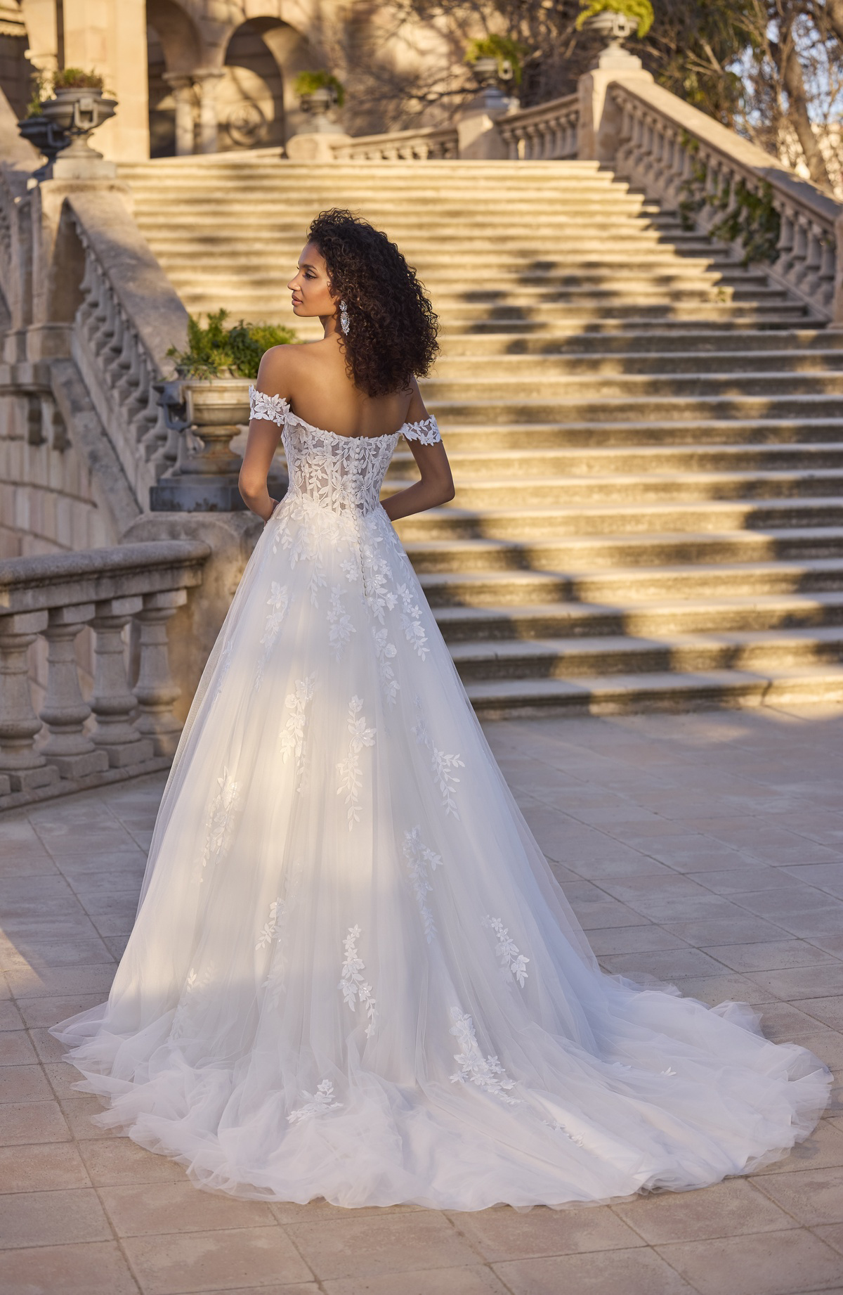 A-lijn trouwjurk met kant 63167 van Morilee. Achteraanzicht van de off-shoulder bandjes en flowy tule rok met sleep.