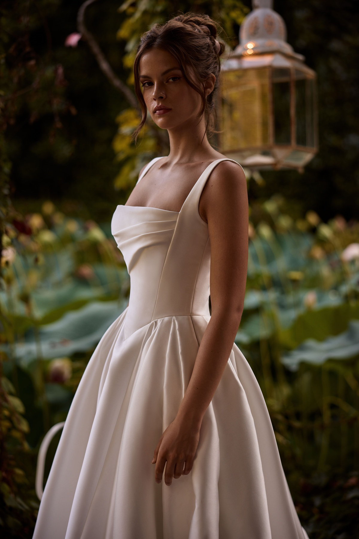 Klassieke prinsessenjurk Ermana van Milla Nova LR. Zijaanzicht van de satijnen bruidsjurk met gedrapeerd lijfje.