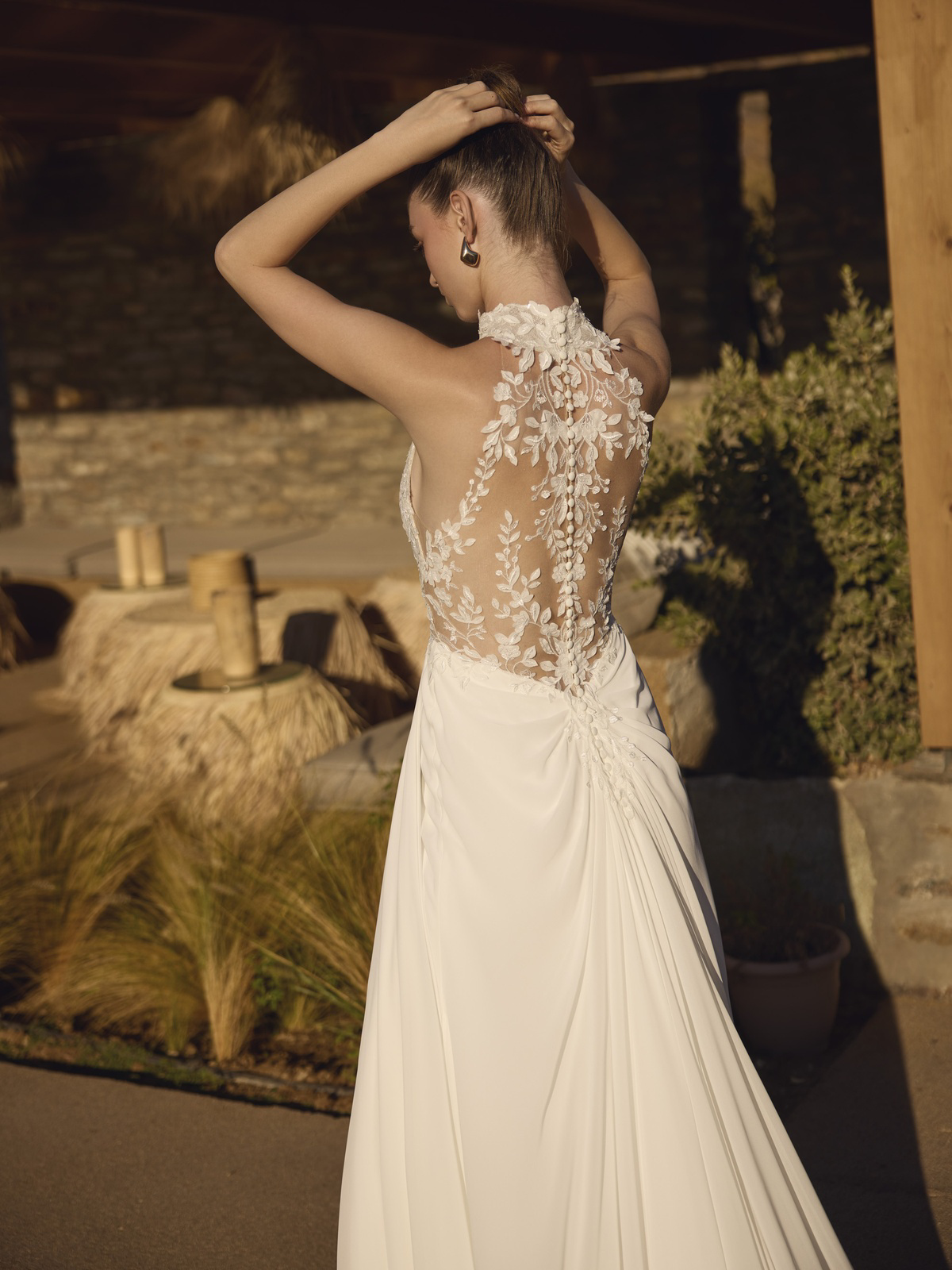 Kanten trouwjurk Helmi van Modeca, achteraanzicht. See-through rug met hoge hals en picpac knoopjes.