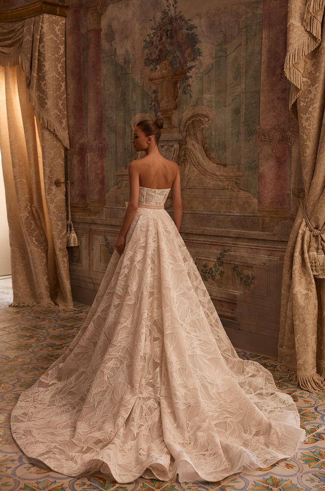 Strapless A-lijn bruidsjurk Octavianna van Aria met open rug. Achteraanzicht van het korsetlijfje en de wijde kanten rok.