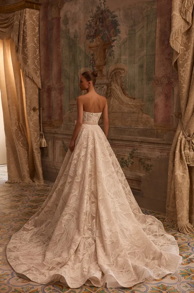 Strapless A-lijn bruidsjurk Octavianna van Aria met open rug. Achteraanzicht van het korsetlijfje en de wijde kanten rok.