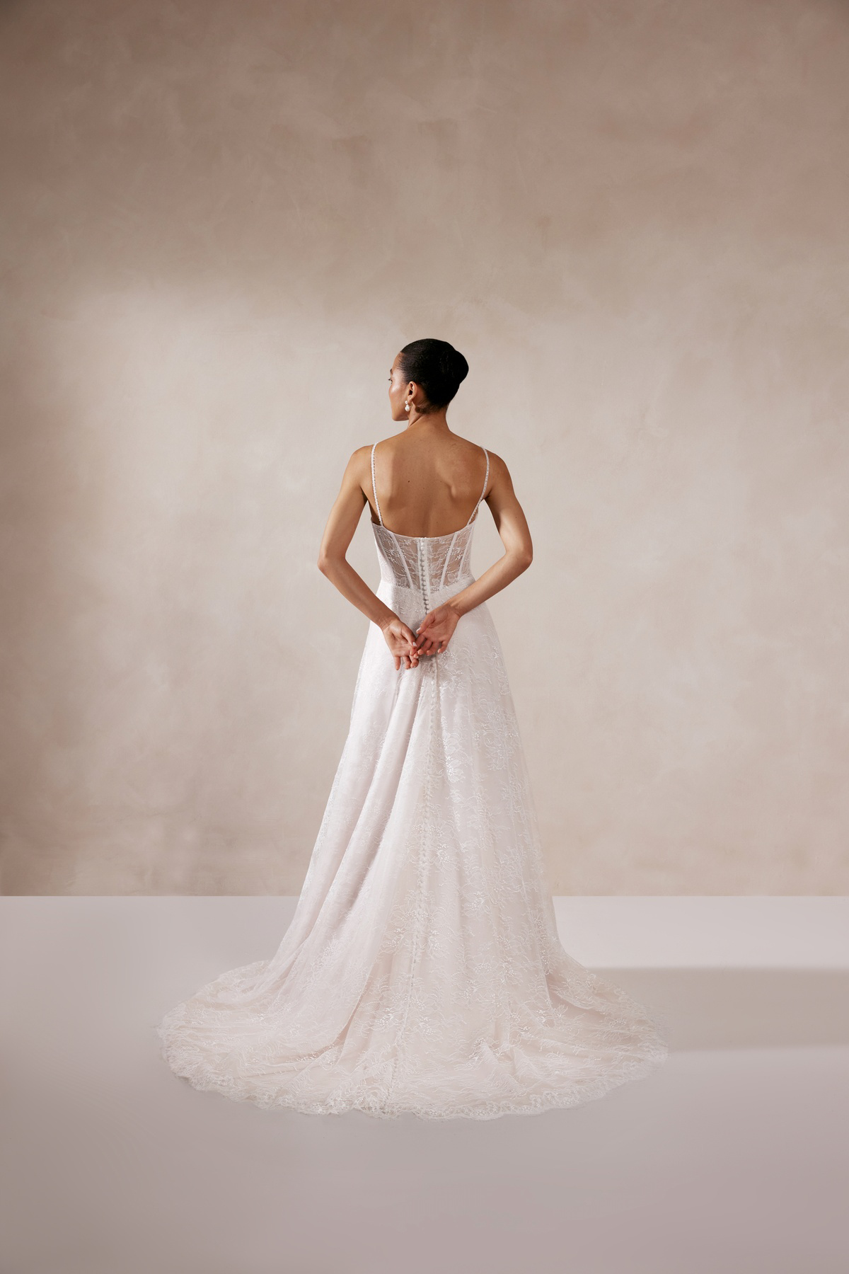 Trouwjurk met lage rug Zia van Adore, achteraanzicht. Volledig kanten A-lijn jurk met een see-through korsetlijfje.