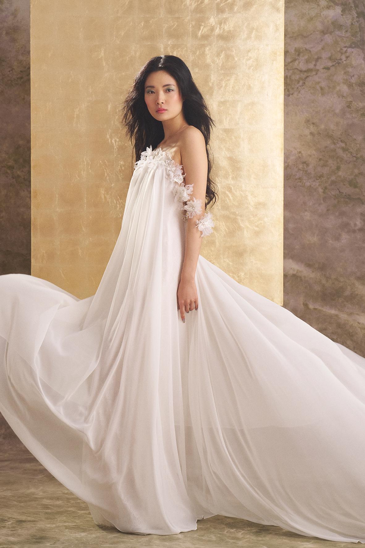 Effortless trouwjurk Lyon van Ines di Santo. Zijaanzicht van de flowy chiffon jurk met 3D bloemen op de arm.