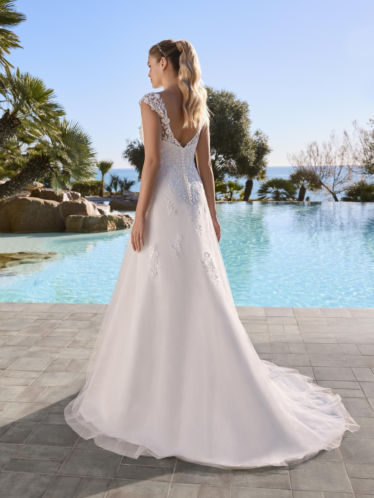 A-lijn trouwjurk Blomster van Ladybird, achteraanzicht. Deze romantische bruidsjurk heeft een lage rug en kanten kapmouwtjes.