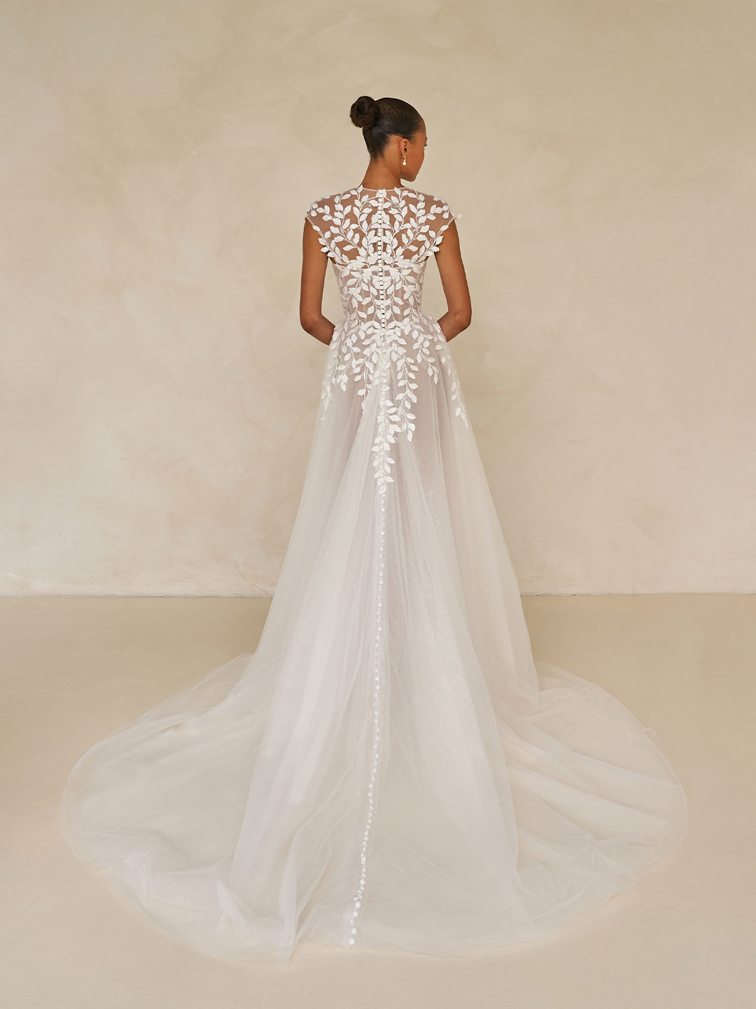 A-lijn trouwjurk met kant Whitley van Madi Lane. Achteraanzicht van de rug met bladmotief, kapmouwtjes en picpac knoopjes.