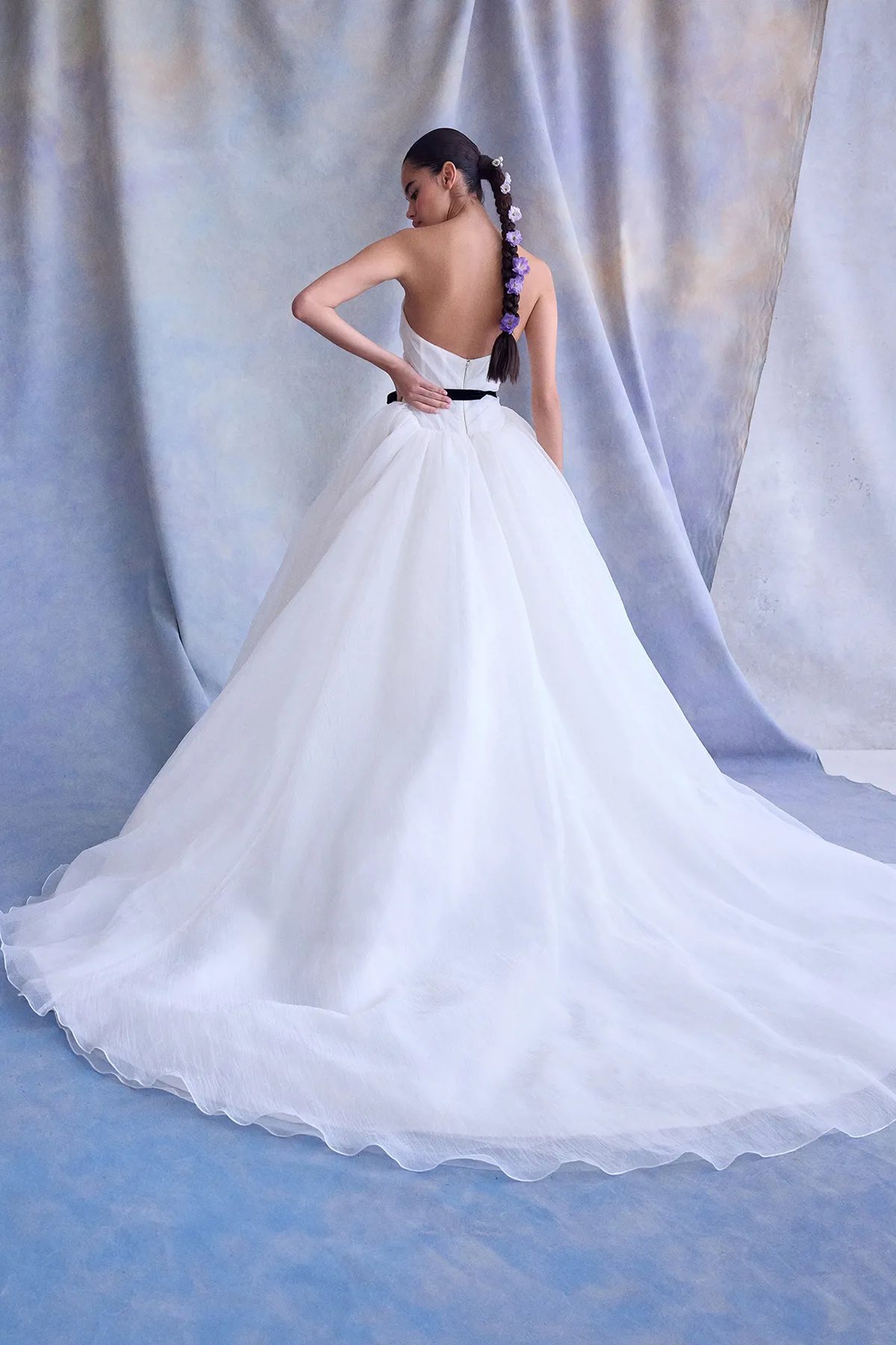 Strapless prinsessen trouwjurk Caspian van Ines di Santo. Achteraanzicht van de wijde rok, lange sleep en zwart ceintuur.