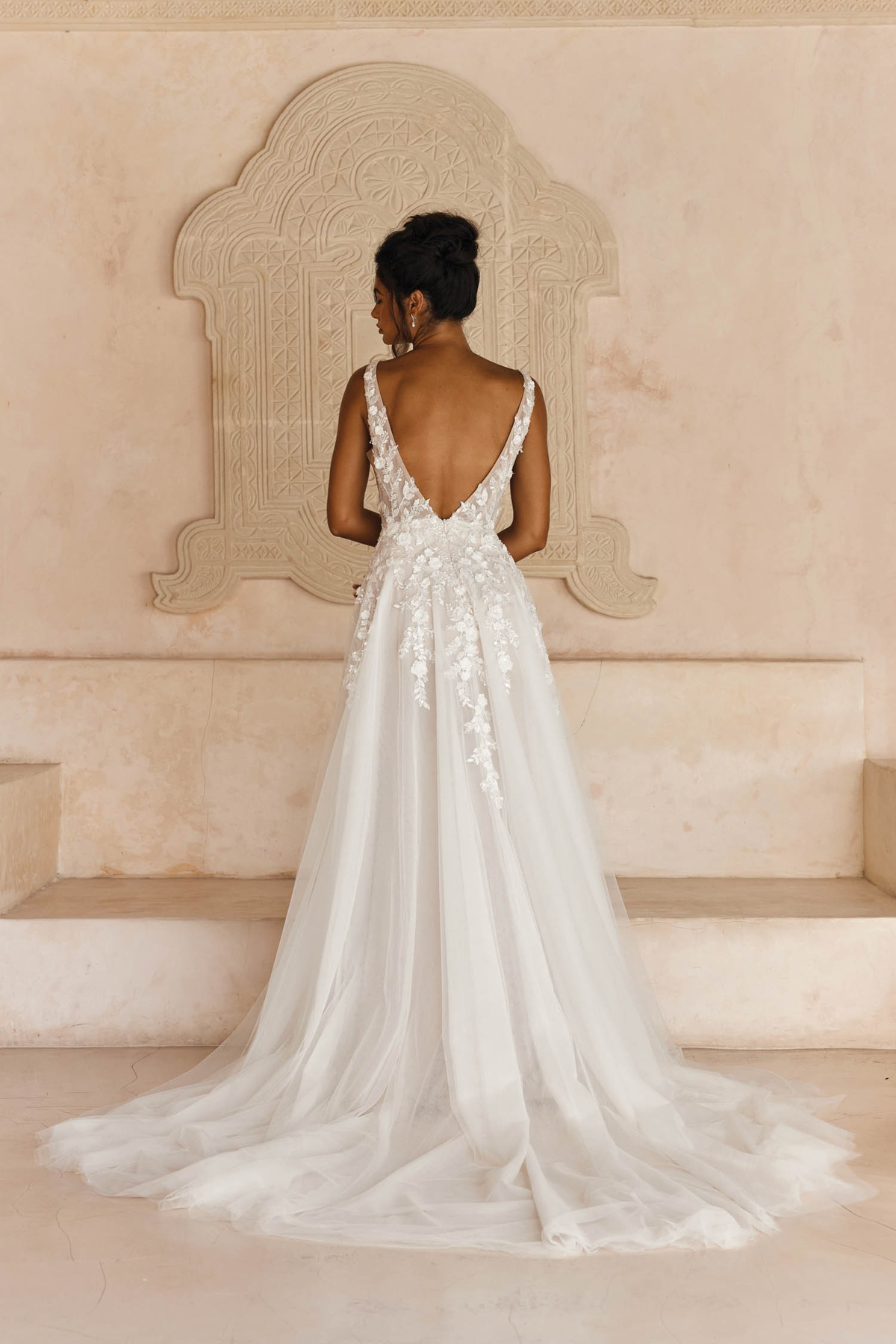 Trouwjurk met lage rug Lyndall van Madi Lane. Achteraanzicht van de A-lijn jurk met 3D kant en een romantische tule rok.